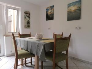 ein Esszimmer mit einem Tisch und vier Stühlen in der Unterkunft Walls 1 in Wallsbüll