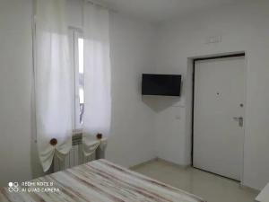 a white room with a table and a tv on a wall at Villa Sandro in Agropoli