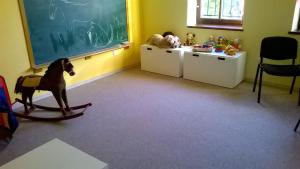 a classroom with a rocking horse and a chalkboard at Apartamenty Przy Parku in Rabka