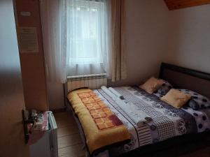 a small bed in a bedroom with a window at Rooms Skorpijon in Žabljak