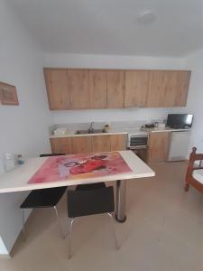 a kitchen with a table with a painting on it at Sofia's Rooms in Himare