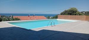 a large swimming pool with the ocean in the background at Suite Smeralda sea view in Castelsardo