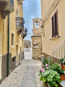 an alley between two buildings with flowers at Suite Smeralda sea view in Castelsardo
