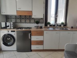 a kitchen with a washing machine and a dishwasher at Dimora San Martino in Offida