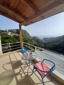 a table and chairs on a balcony with a view at Sofia's Rooms in Himare