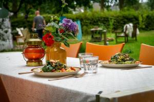 a table with two plates of food and flowers on it at Het binnenerf yurt en keetjes in Nieuwleusen