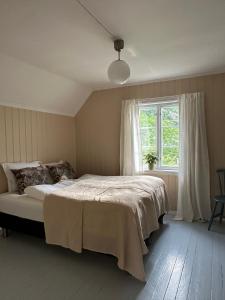 a bedroom with a large bed and a window at Veslegarden in Lærdalsøyri