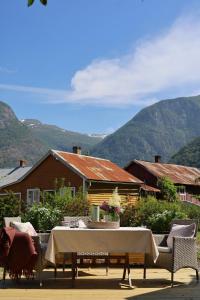 a table and chairs with mountains in the background at Veslegarden in Lærdalsøyri