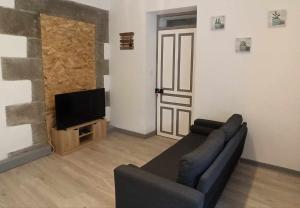 salon z kanapą i telewizorem z płaskim ekranem w obiekcie Relais De La Tour w mieście Callac