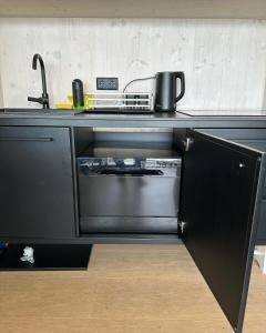 eine schwarze Küche mit Herd und Spüle in der Unterkunft BEACHHOUSE #1 - Buqez Resort in Drage