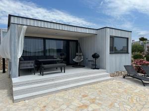 ein Gebäude mit einer Terrasse mit einer Bank darauf in der Unterkunft BEACHHOUSE #1 - Buqez Resort in Drage + 12 Fotos