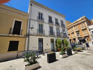 een groot wit gebouw met potplanten ervoor bij Appartamento Adiosa in Cagliari