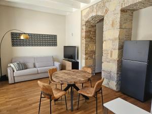 een woonkamer met een tafel, stoelen en een bank bij Appartamento Adiosa in Cagliari