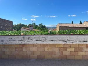 a brick retaining wall with a garden of flowers at Maison avec superbe terrasse tropézienne in Adissan +7 photos