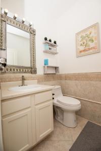 un bagno con un water, un lavandino e uno specchio di InHomeStays a Lakewood Altre 53 foto