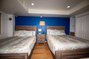 twee bedden in een slaapkamer met blauwe muren bij InHomeStays in Lakewood