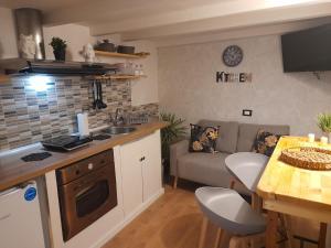 a kitchen and a living room with a couch at Sweet home Palermo in Palermo