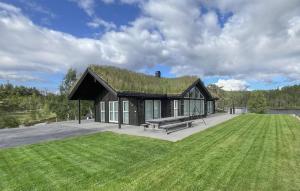 a house with a grass roof with a bench at Gorgeous Home In Evje With Lake View in Evje
