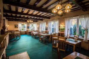 a dining room with tables and chairs and windows at Penzion & Restaurant Raimund in Starý Smokovec