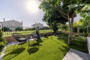 a garden with two chairs and a table in the grass at Marelia Garden House in Mitikas