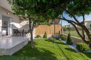 a backyard with a lawn with a tree at Marelia Garden House in Mytikas
