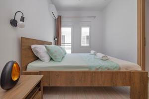 een slaapkamer met een groot bed met een houten hoofdeinde bij Andreas Rodos Apartment in Rhodos-stad +8 foto's