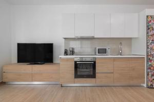 een keuken met een fornuis en een tv bij Andreas Rodos Apartment in Rhodos-stad