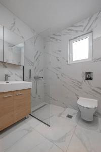 een witte badkamer met een toilet en een wastafel bij Andreas Rodos Apartment in Rhodos-stad