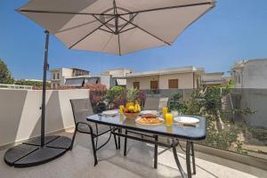 een patio tafel met een parasol op een balkon bij Andreas Rodos Apartment in Rhodos-stad