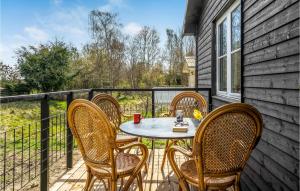 a patio with a table and chairs on a balcony at 3 Bedroom Cozy Home In Kirke Hyllinge in Kirke-Hyllinge