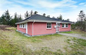 a small red house in the middle of a field at Holiday Home Umanaksvej Rømø Denm in Bolilmark