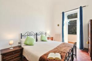 une chambre avec un lit avec des oreillers verts et une fenêtre dans l'établissement Villa Orsini Peccioli - Villa storica ad uso esclusivo con piscina, à Peccioli 75 autres photos