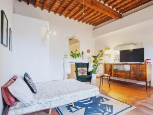 a living room with a bed and a tv at Casa Aida Luxury Apartment in the Heart of Lucca in Lucca