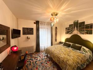 a bedroom with a bed and a chandelier at Chambres d'hôtes Les Carmélites in Guingamp