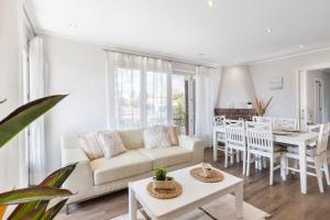 a living room with a white couch and a table at Villa Paraíso - Piscina Playa Barbacoa Wifi in San Juan de Alicante