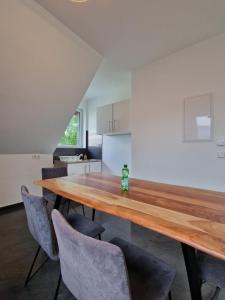 a kitchen and dining room with a wooden table and chairs at Haus im Grünen - App OG in Stemwede