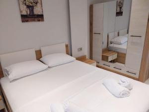 a bedroom with a white bed and a mirror at LUXURY Stay By the Beach in Neoi Epivates