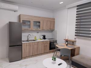 a kitchen with a stainless steel refrigerator and a table at LUXURY Stay By the Beach in Neoi Epivates