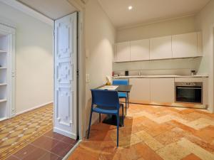 a kitchen with a table and a blue chair at Appartamento Moon and Stars 7 in Muralto