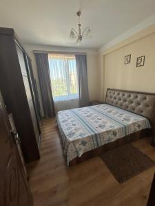 a bedroom with a bed in a room with a window at Family Trip in Kutaisi
