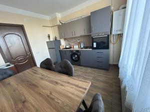 a living room with a table and a kitchen at Family Trip in Kutaisi