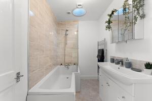 a white bathroom with a tub and a sink at Sleek and Stylish Abode - Parking in Bristol +31 photos