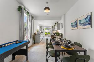 a dining room with a table and a pool table at Sleek and Stylish Abode - Parking in Bristol