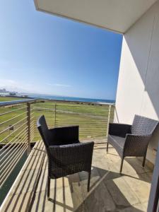 two chairs on a balcony with a view of the ocean at Accommodation Front - Ocean View 2 Sleeper in Durban