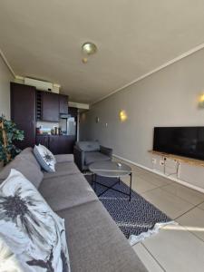 a living room with a couch and a flat screen tv at Accommodation Front - Ocean View 2 Sleeper in Durban