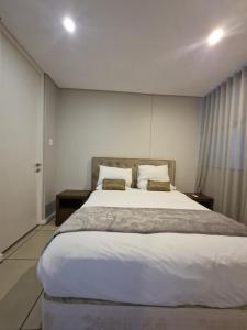 a bedroom with a large white bed with two pillows at Accommodation Front - Ocean View 2 Sleeper in Durban