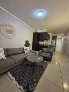 a living room with a couch and a table at Accommodation Front - Ocean View 2 Sleeper in Durban