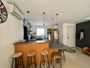 a kitchen with a counter and bar with stools at Maison Lili 2 chambres in Conca