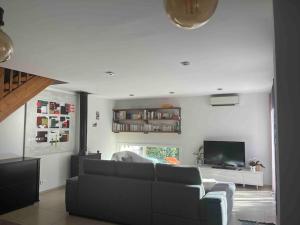 a living room with a couch and a tv at Maison Lili 2 chambres in Conca