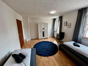 a bedroom with two beds and a blue rug at OhPardon! GAILDORF - Monteurwohnung im 1 OG, Einzelbetten, Garten in Gaildorf